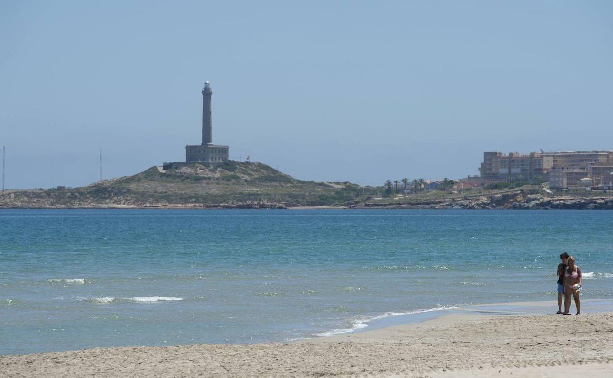 Dos viandantes caminan por una playa de La Manga, este martes.