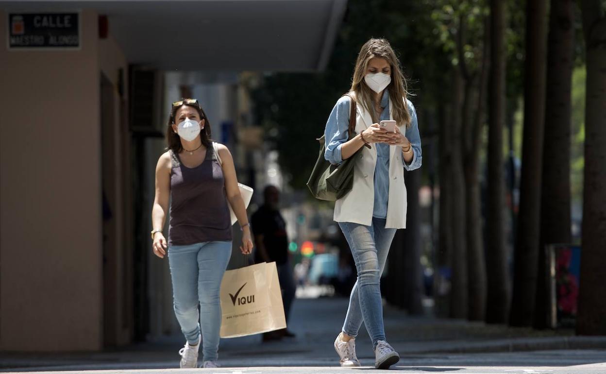 Dos mujeres protegidas con mascarilla pasean por el centro de Murcia, este jueves.