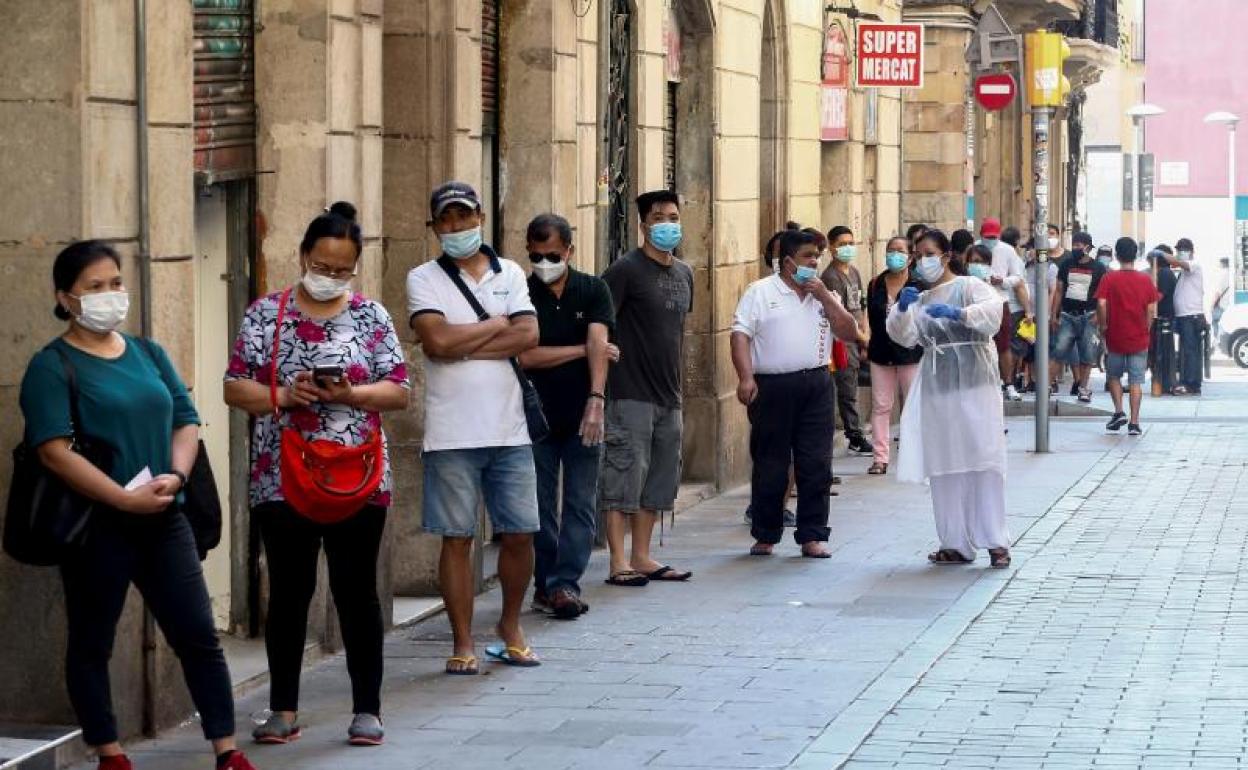 Colas para recoger comida en Barcelona. 