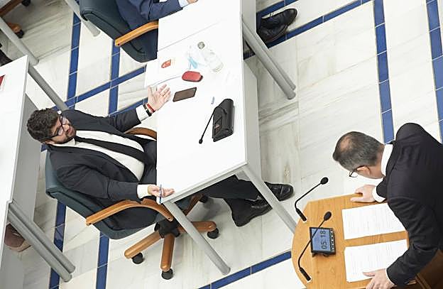 El presidente López Miras extiende los brazos ante Diego Conesa, secretario general del PSRM, que comparece en el Debate del Estado de la Región.