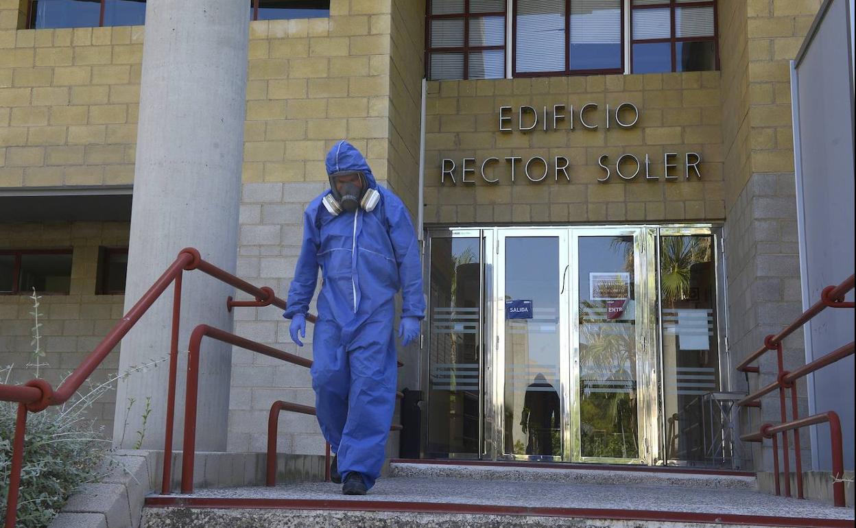 Un miembro del equipo de desinfección saliendo del edificio.