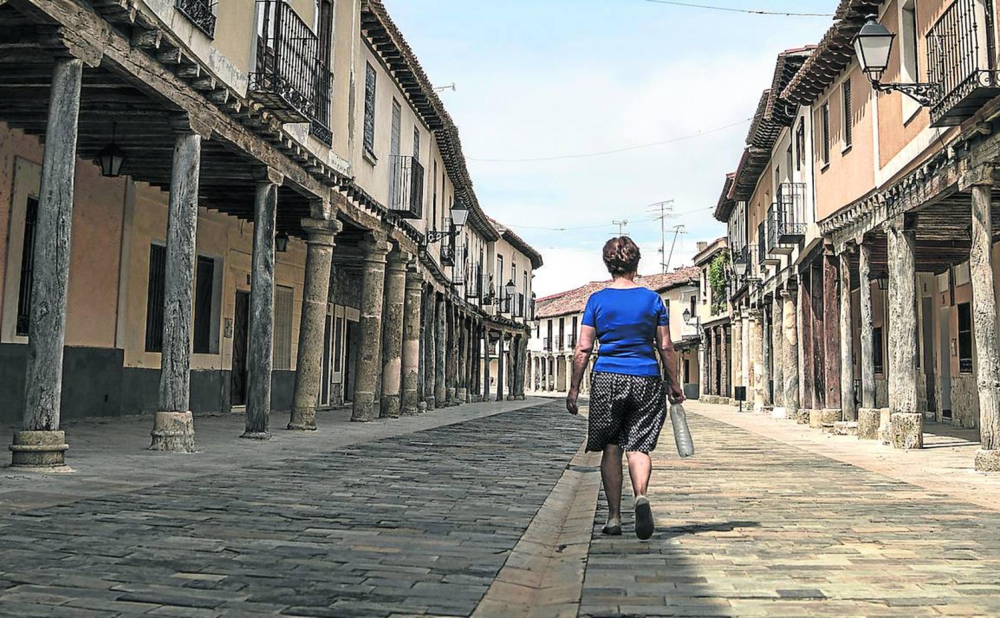 Una mujer recorre el centro de Ampudia, en la pintoresca y desolada Tierra de Campos.