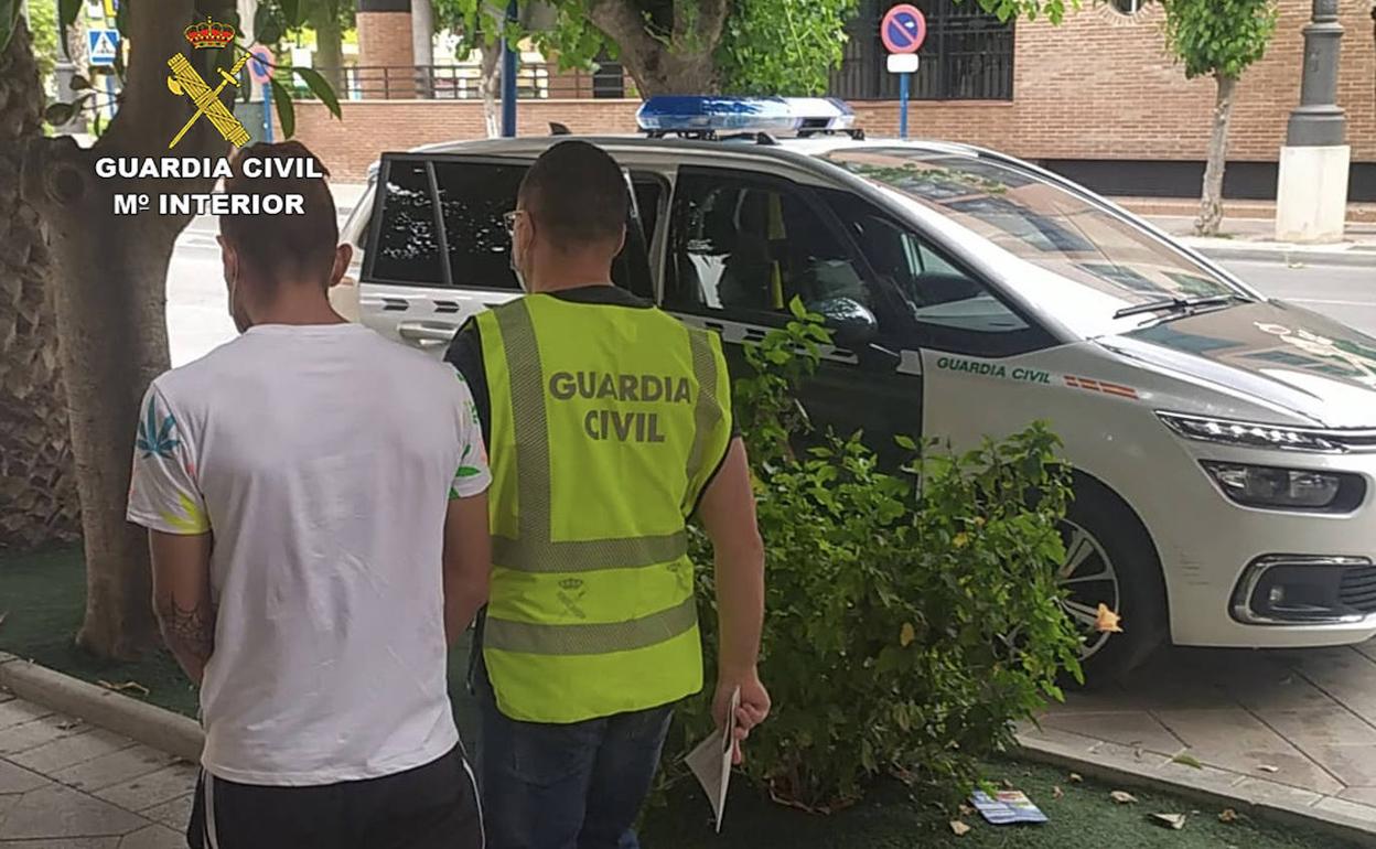 Uno de los detenidos, junto a un agente de la Guardia Civil.