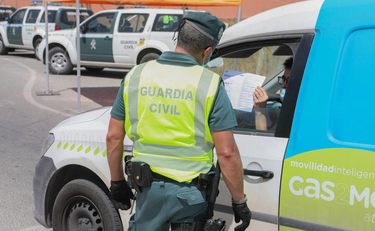 Un conductor muestra una acreditación para tratar de entrar en el municipio de Totana, ayer, en uno de los controles instalados por la Guardia Civil. 