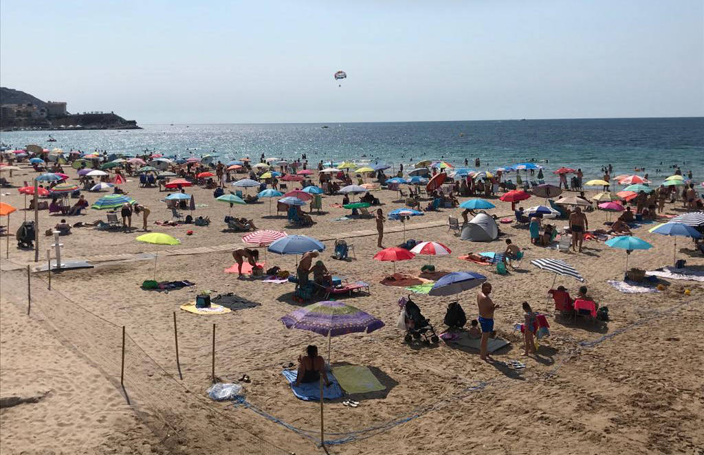 La playa de Levante de Benidorm se muestra como diseñada por un aparejador; solo los críos y las pelotas escapan de los cercados, que todo el mundo acata como un dogma.