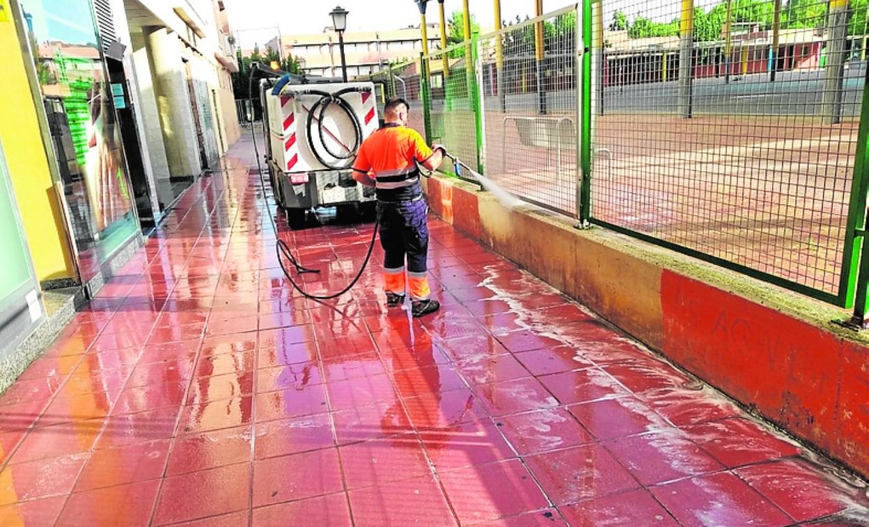 Un operario desinfecta la calle que linda con un colegio. 