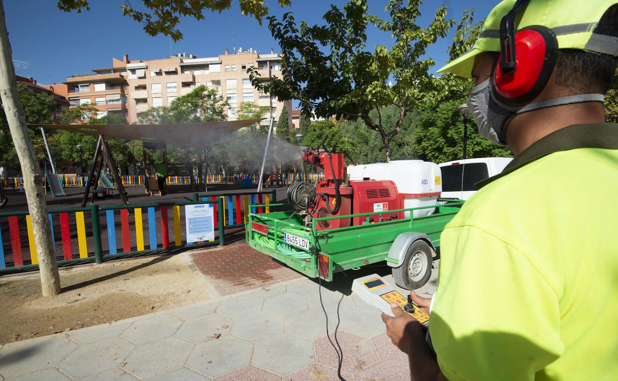 Un operario acciona el mando para que el cañón comience a pulverizar lejía diluida en agua sobre la zona de juegos infantiles del jardín de las Tres Copas.
