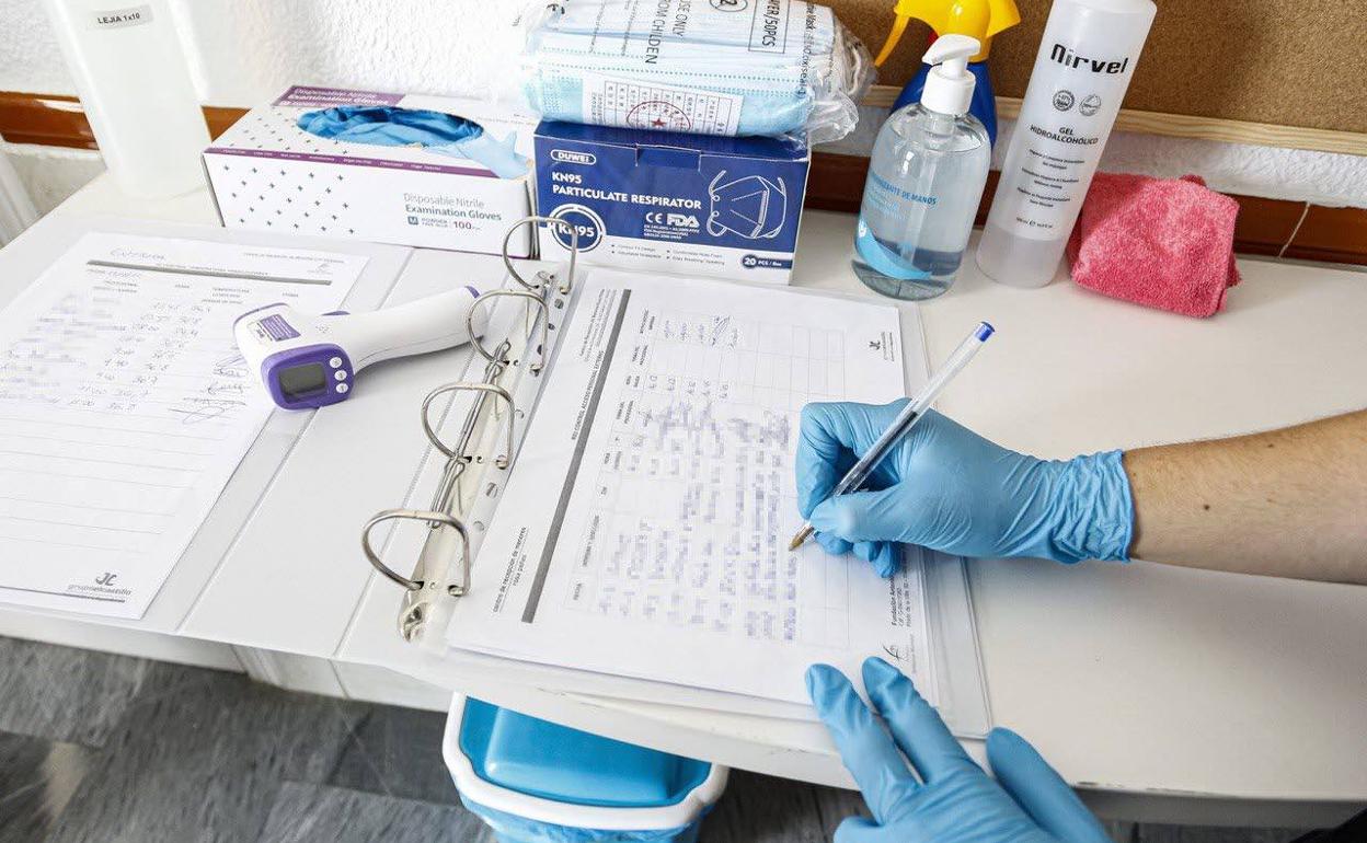 Un sanitario registra controles de temperatura. 