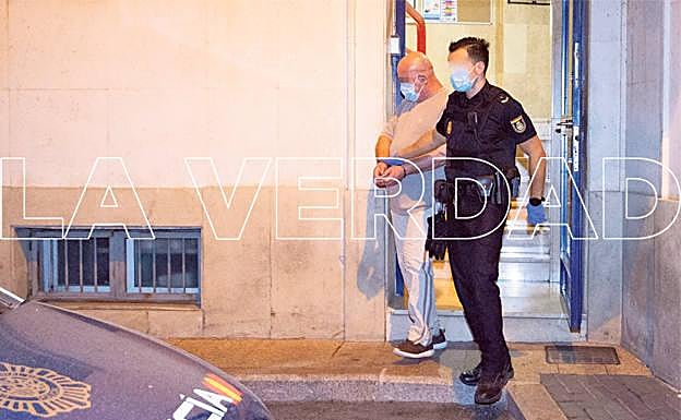 El presunto asesino, junto a un agente, sale a última hora de anoche de las dependencias policiales.