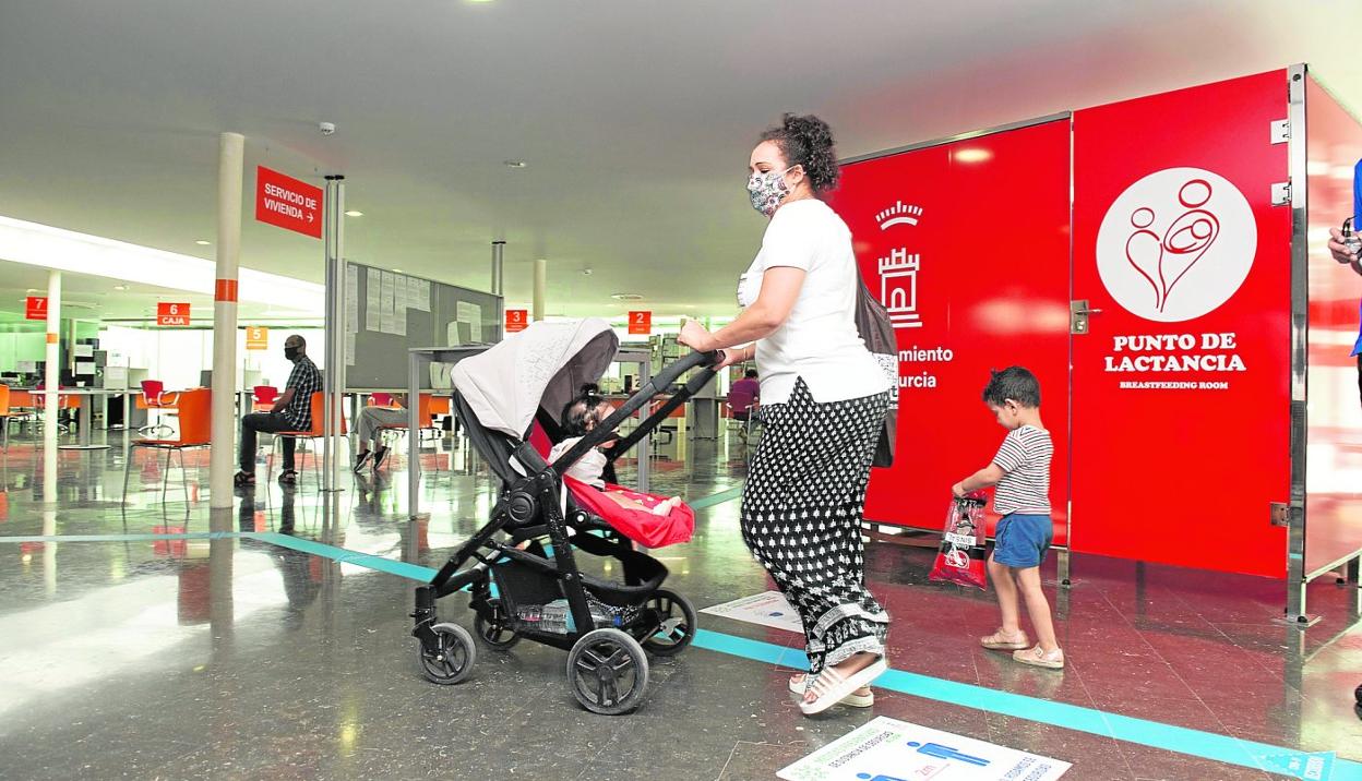 Una madre con sus dos hijos pasa por delante de la sala de lactancia que ya funciona desde hace unos meses en el edificio municipal de Abenarabi. 