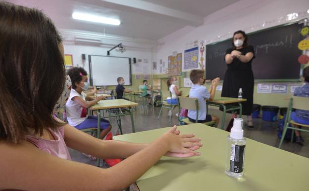 Los niños se desinfectan las manos en el primer día de clase. 