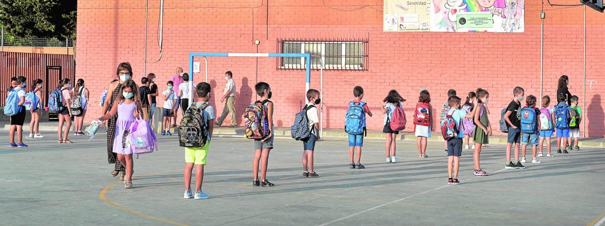 Alumnos del colegio Nuestra Señora de Los Ángeles de El Esparragal, en Murcia, forman filas con la distancia de seguridad antes de entrar a su primera clase en seis meses. 