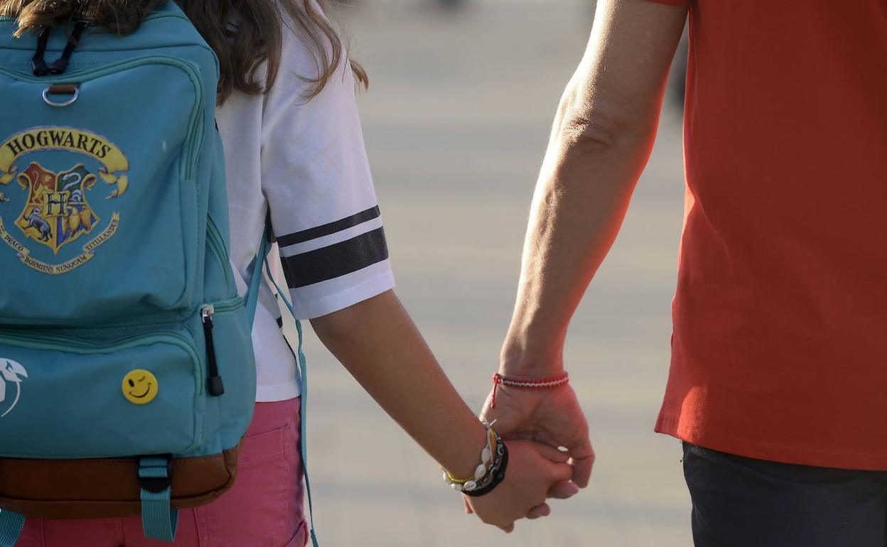 Una niña es acompañada al colegio por su padre, en una imagen de archivo.