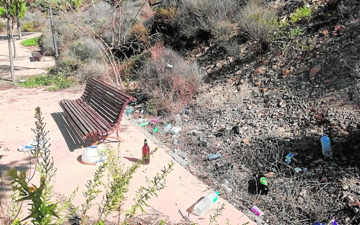 Botellas, botes y bolsas tras una noche de botellón en un paseo de El Esparragal.