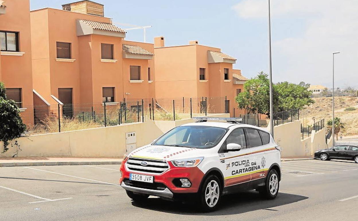 Un vehículo de la Policía de Cartagena patrulla por una urbanización ocupada en Isla Plana, hace meses.