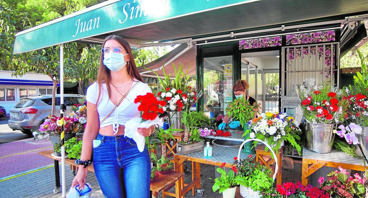 Una joven, ayer, con un ramo de flores comprado en el quiosco situado en la puerta del cementerio de Jesús. 