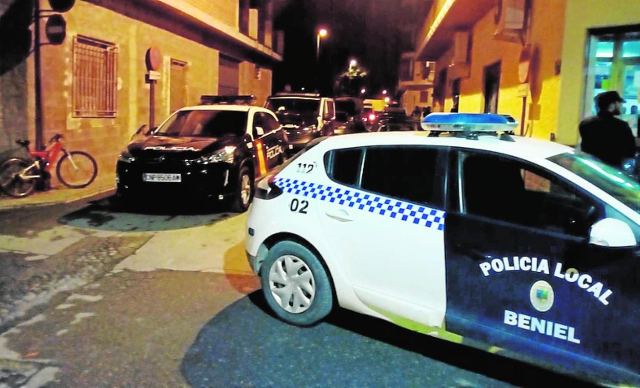 Varios coches de la Policía durante la operación en Beniel. 