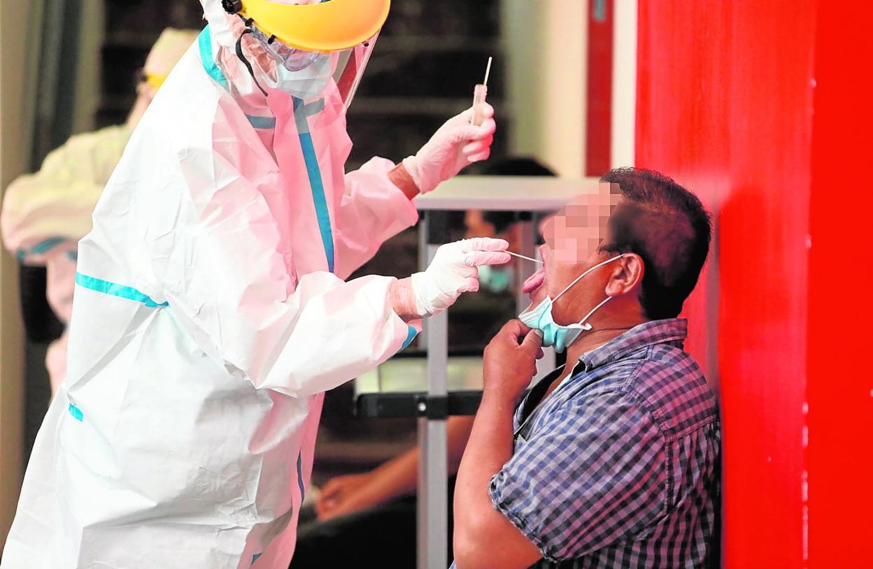 Un sanitario toma una muestra para una prueba PCR en Lorca. 