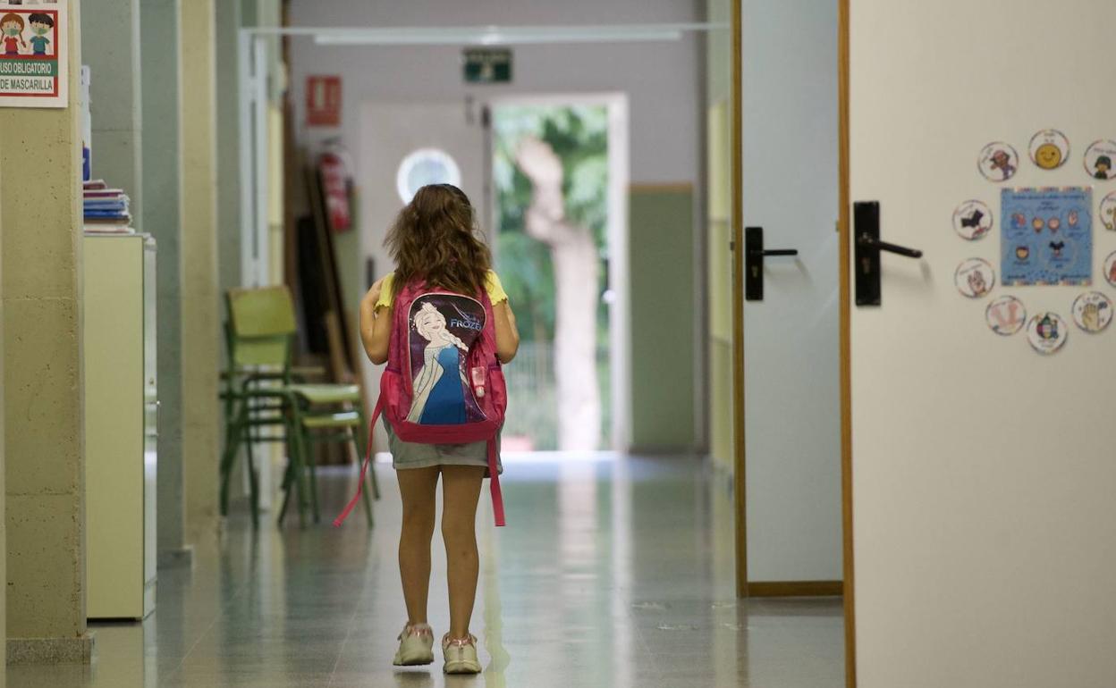 Una niña camina por el pasillo de su colegio, en una fotografía de archivo.