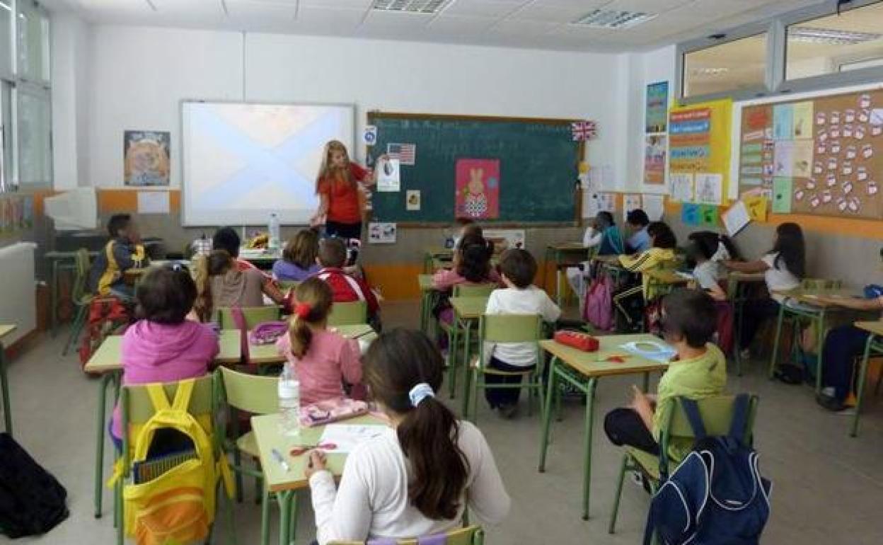 Una profesora imparte clase en un colegio. 