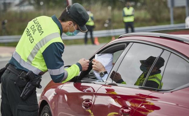Un agente de la Guardia Civil de Tráfico comprueba la documentación de un conductor en un control policial en Pamplona (Navarra).