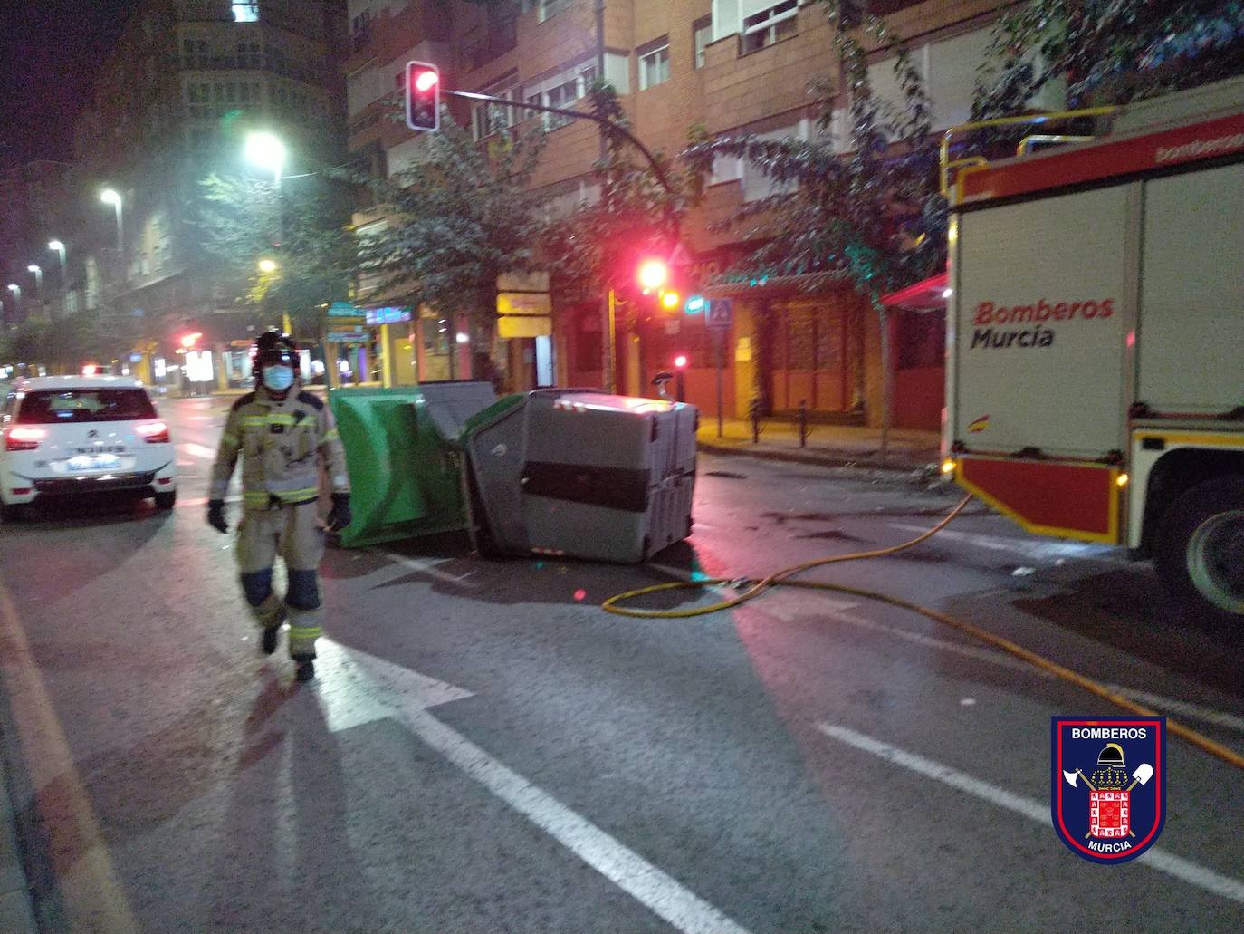 Un bombero junto a uno de los contenedores quemados en Murcia.
