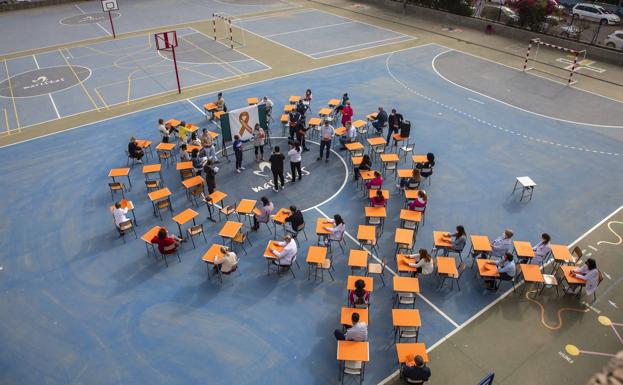 Mesas cubiertas con cartulinas naranjas formando un gran lazo en el colegio Maristas de Cartagena.