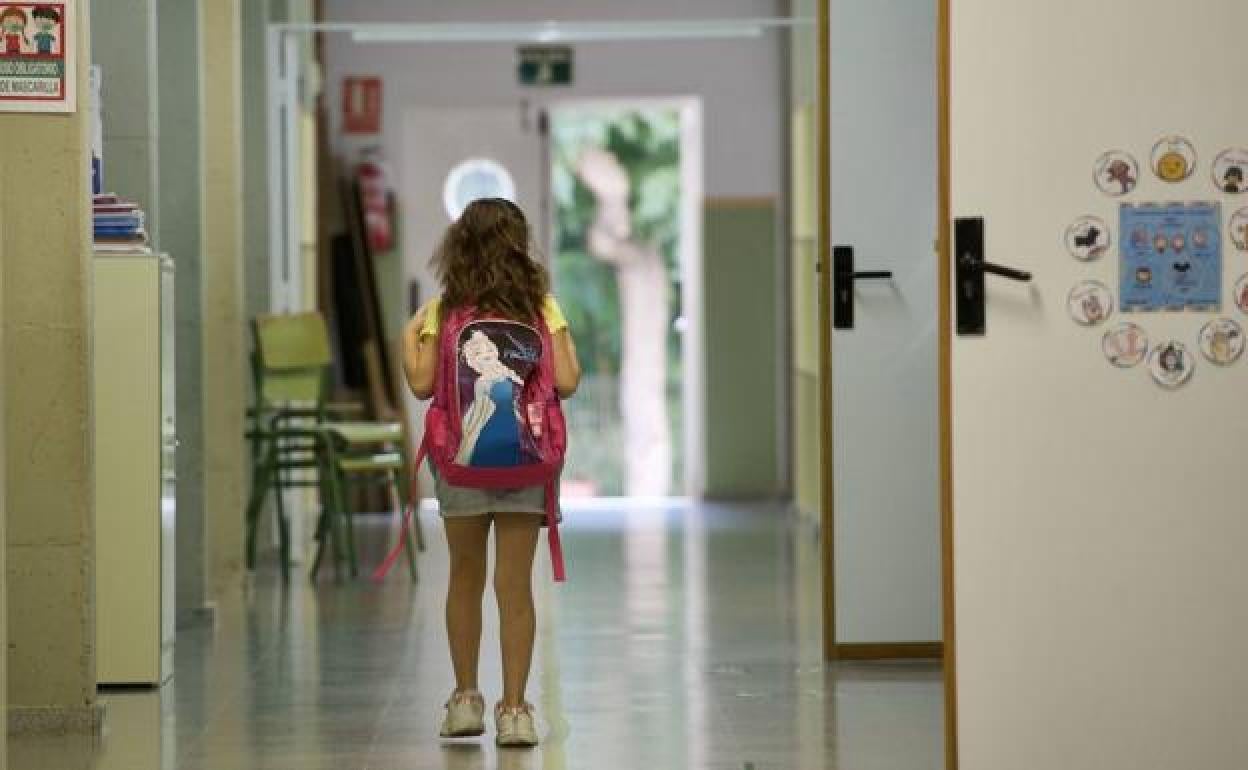 Una niña camina por un pasillo de su colegio, en una fotografía de archivo.