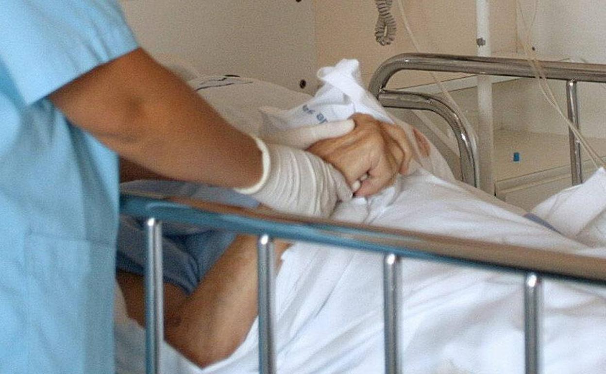 Un enfermero asiste a un enfermo terminal.