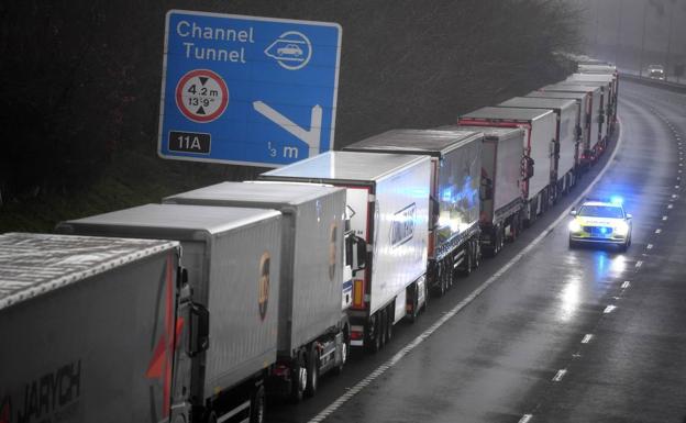 Un coche de policía pasa junto a una larga cola de camiones que permanecen atrapados a causa del cierre de la frontera con Reino Unido decretada por Francia, este lunes en Kent, Reino Unido.