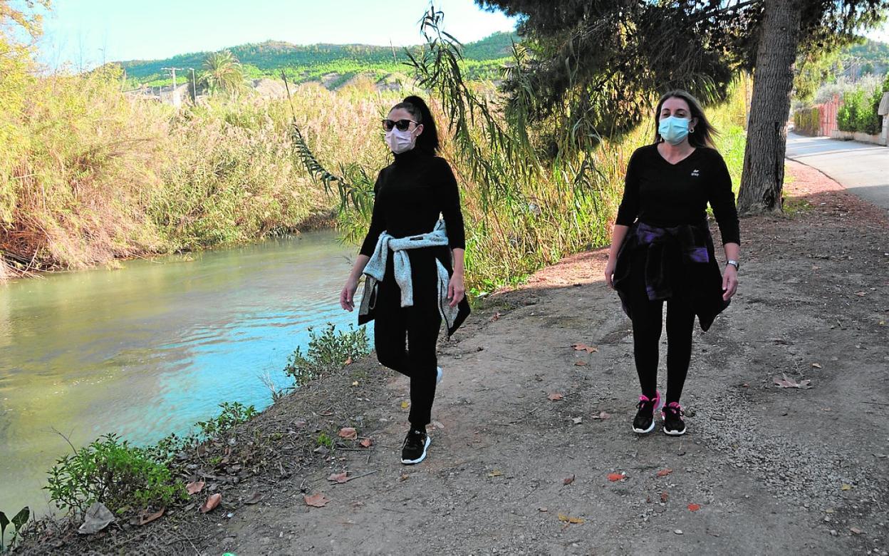 Dos senderistas disfrutan de un paseo por la ribera del río a su paso por Cieza, en el Argaz. 