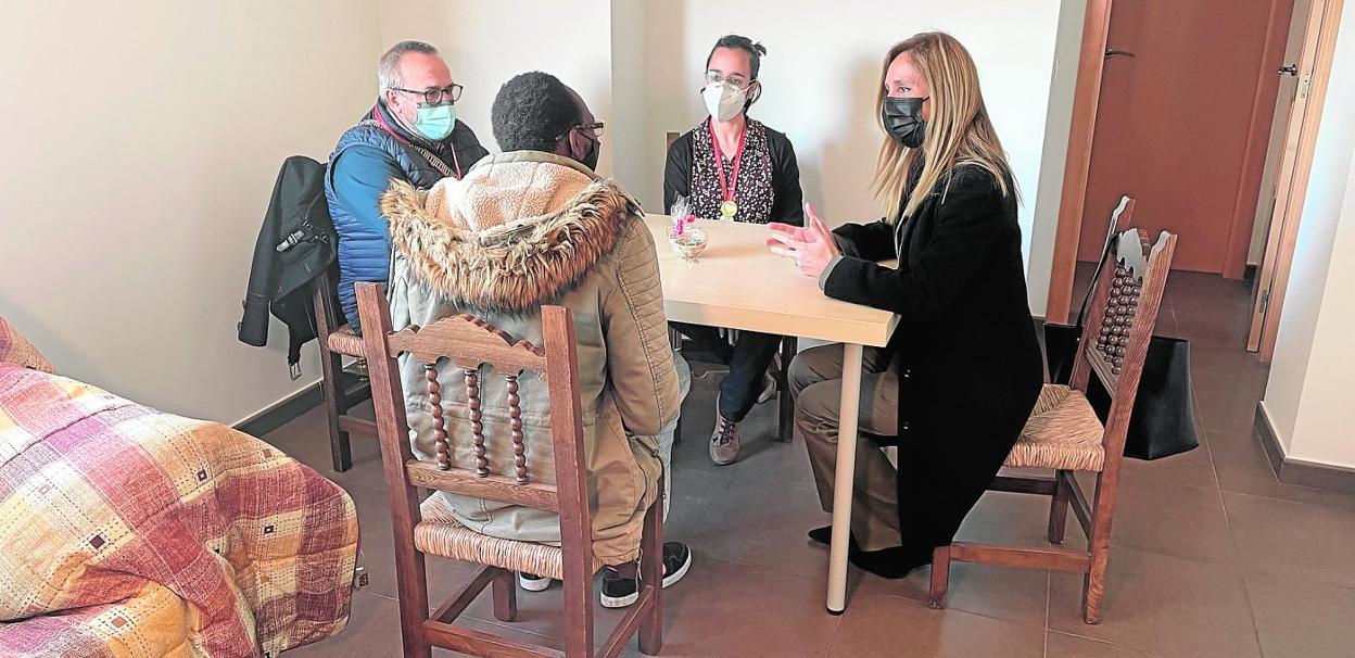 Kevin, usuario de Jesús Abandonado (centro), charla con la concejal Pilar Torres (d) y con los colaboradores de la Fundación Alfredo Trívez y Soledad López en la vivienda donde reside ahora. 