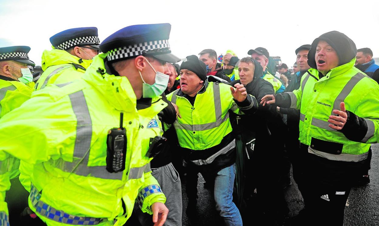 Un grupo de transportistas afectados por el cierre de la frontera se enfrentan a policías en el puerto de Dover, en Inglaterra. 