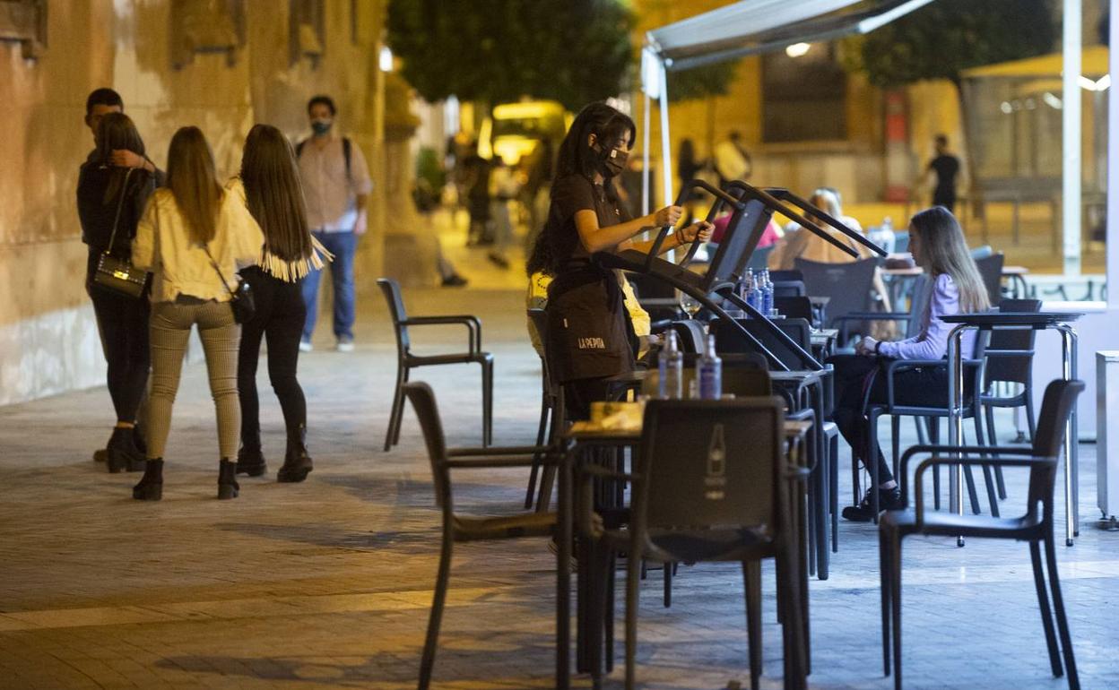 Una camarera recoge una terraza de Murcia en una imagen de archivo.