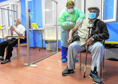 Imagen secundaria 1 - Jaime Pérez, portavoz del Comité de Seguimiento Covid y receptor del pequeño gran cargamento de vacunas, comprueba el envío recibido en la residencia de mayores de San Pedro; la enfermera Sonia Caravaca suministra sus respectivas dosis a varios residentes del centro marmenorense, y uno de los viales de Pfizer que fueron administrados ayer.