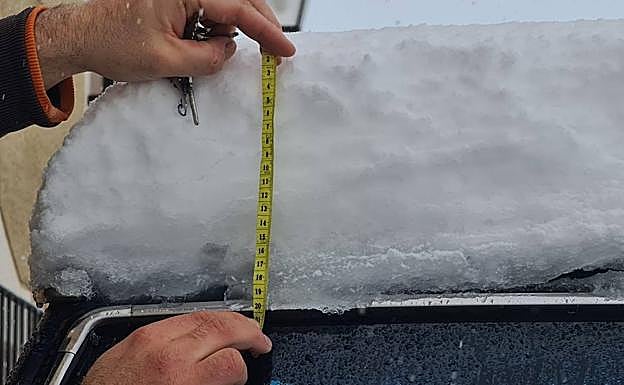 Un vecino de El Moralejo mide casi 20 centímetros de nieve sobre su coche.