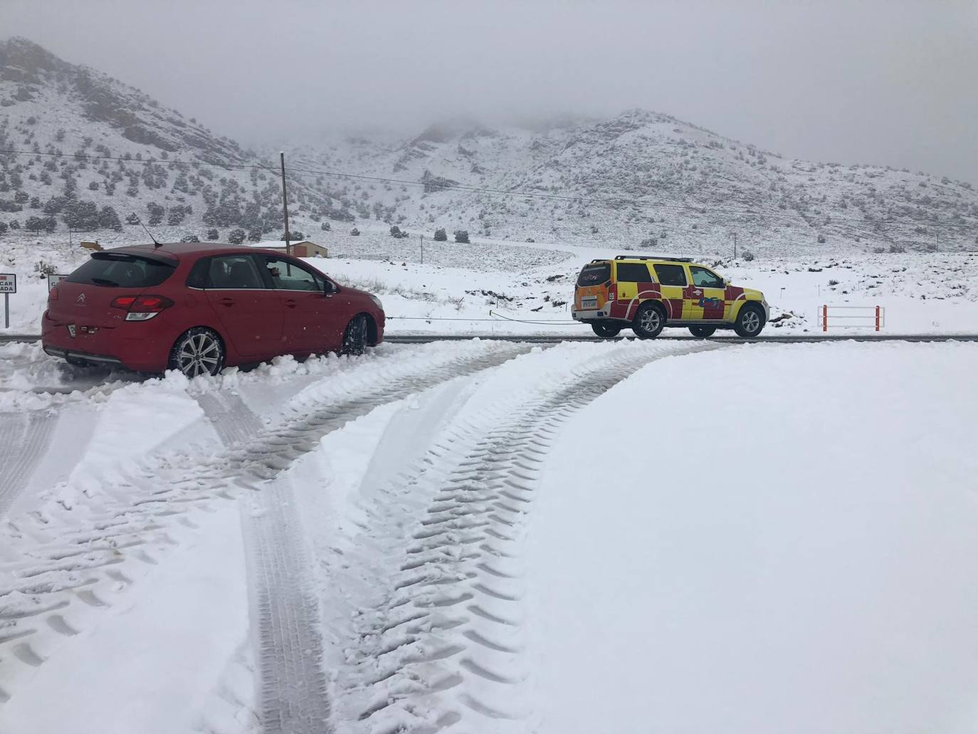 Rescate de un coche atascado en la nieve en Los Royos (Caravaca), este viernes.