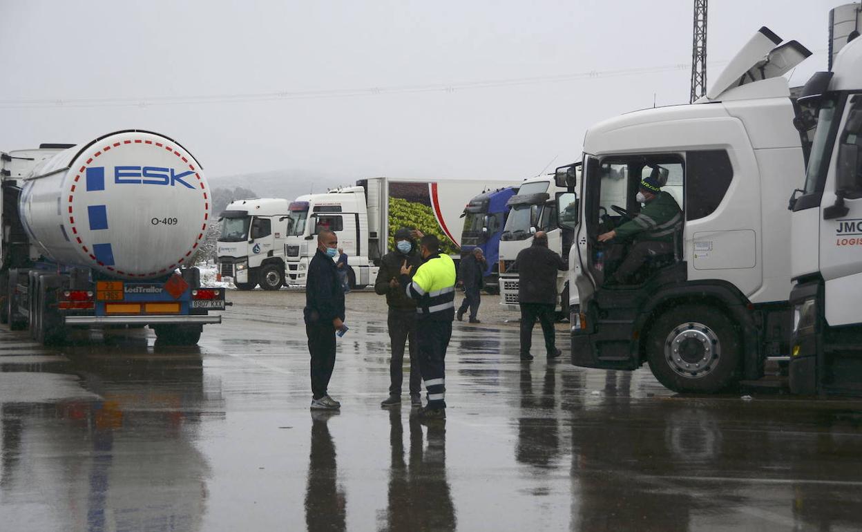Varios camioneros hablan junto a la Venta Pascual, tras quedar retenidos por la nieve.