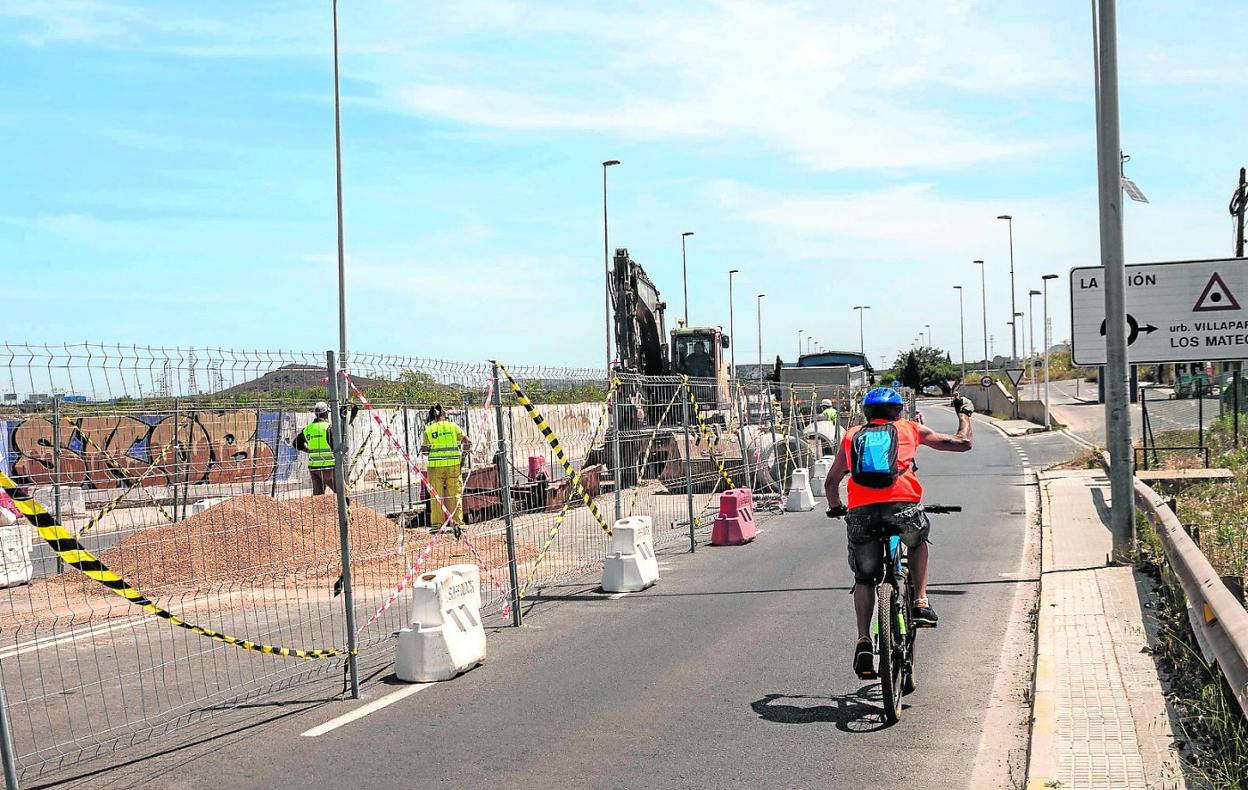 Un ciclista pasa junto a las obras de Villa París, en la carretera de La Unión, en junio. 
