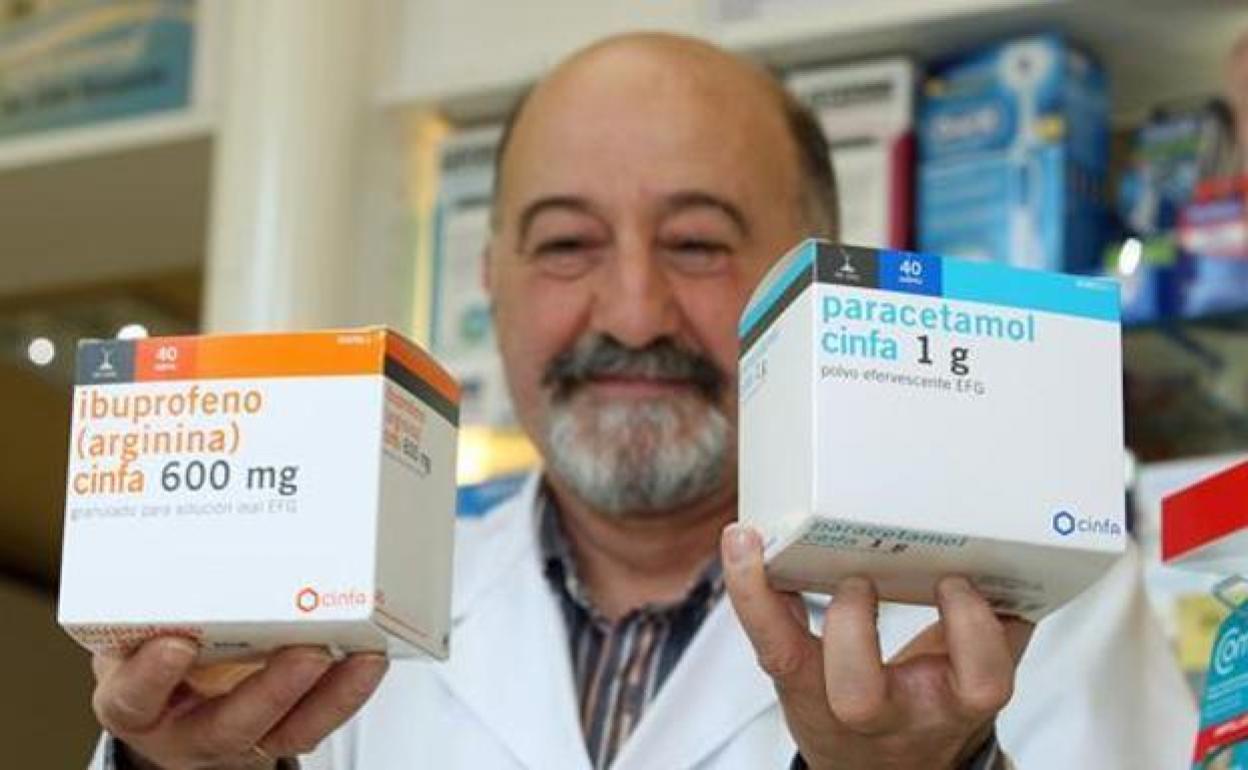 Un farmacéutico muestra una caja de ibuprofeno y otra de paracetamol en una foto de archivo.