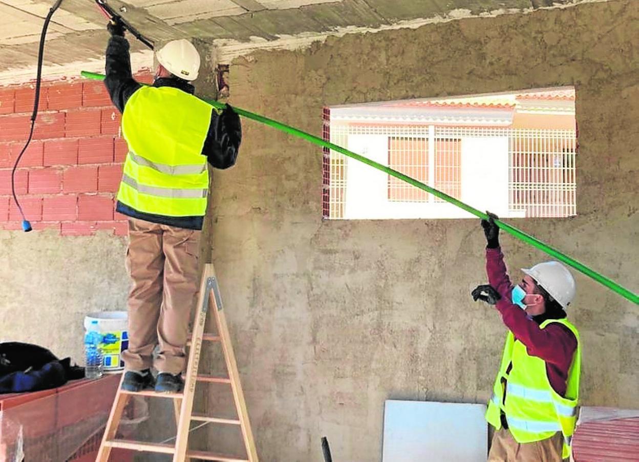 Dos alumnos realizando prácticas en un curso. 