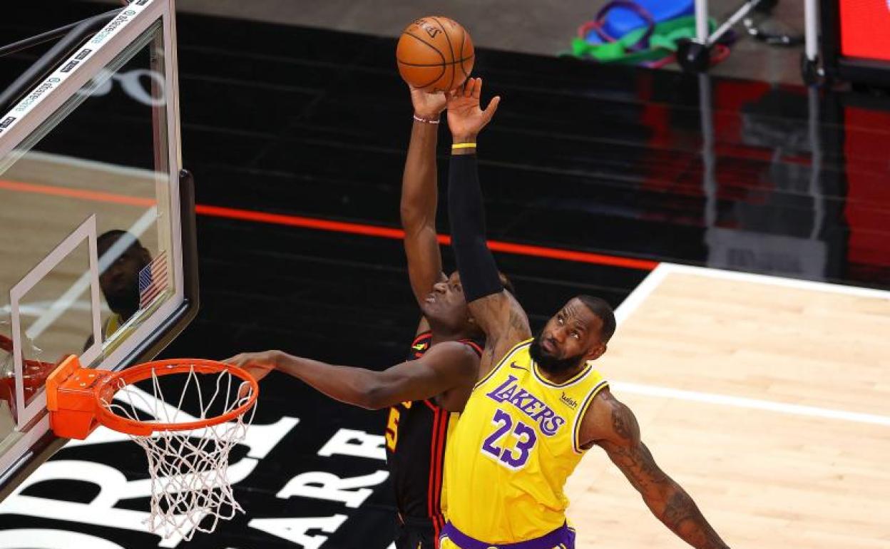 LeBron James, de Los Angeles Lakers, defiende un pase destinado a Clint Capela, de los Atlanta Hawk 