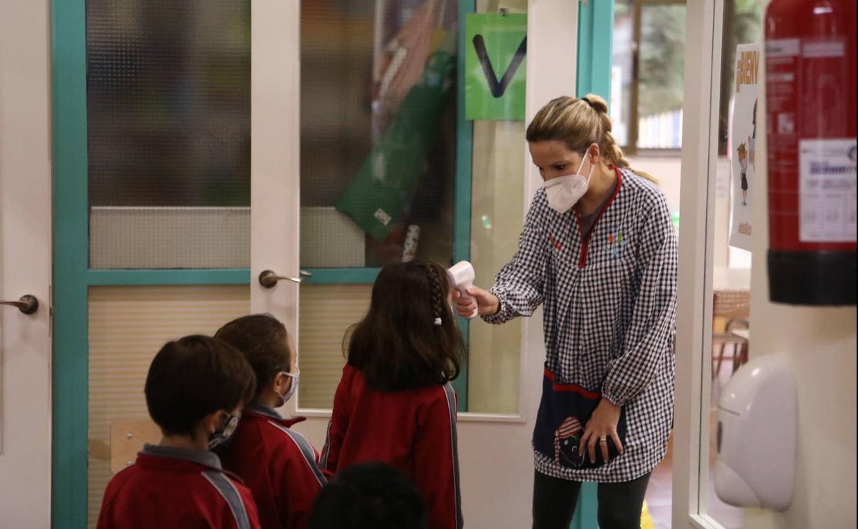 Una profesora toma la temperatura a sus alumnos en un colegio de Lorca.