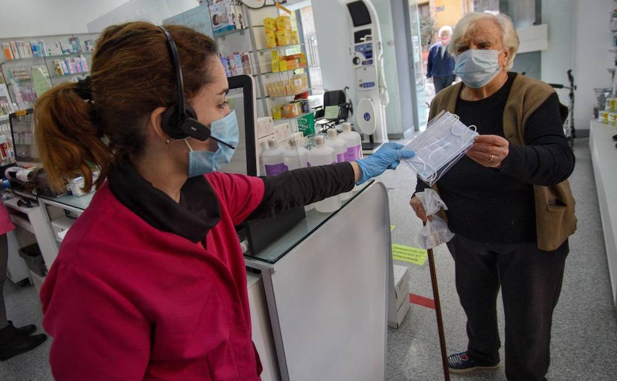 Una mujer recogiendo una mascarilla en Murcia en una foto de archivo.