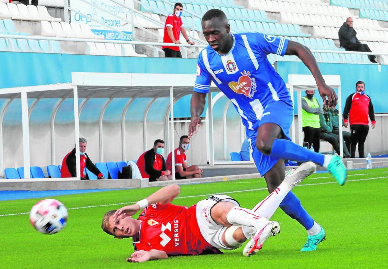 Musoni busca un balón con Edu Luna en el suelo, en el partido de la primera vuelta. 
