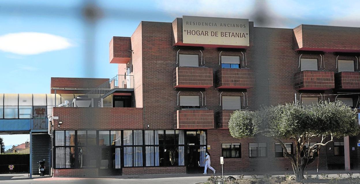 Una empleada camina frente a la fachada de la residencia de mayores Hogar de Betania. 