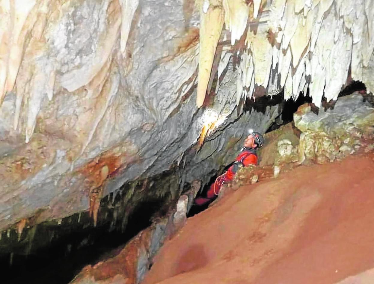 Un espeleólogo, en el descenso en la sima descubierta. 