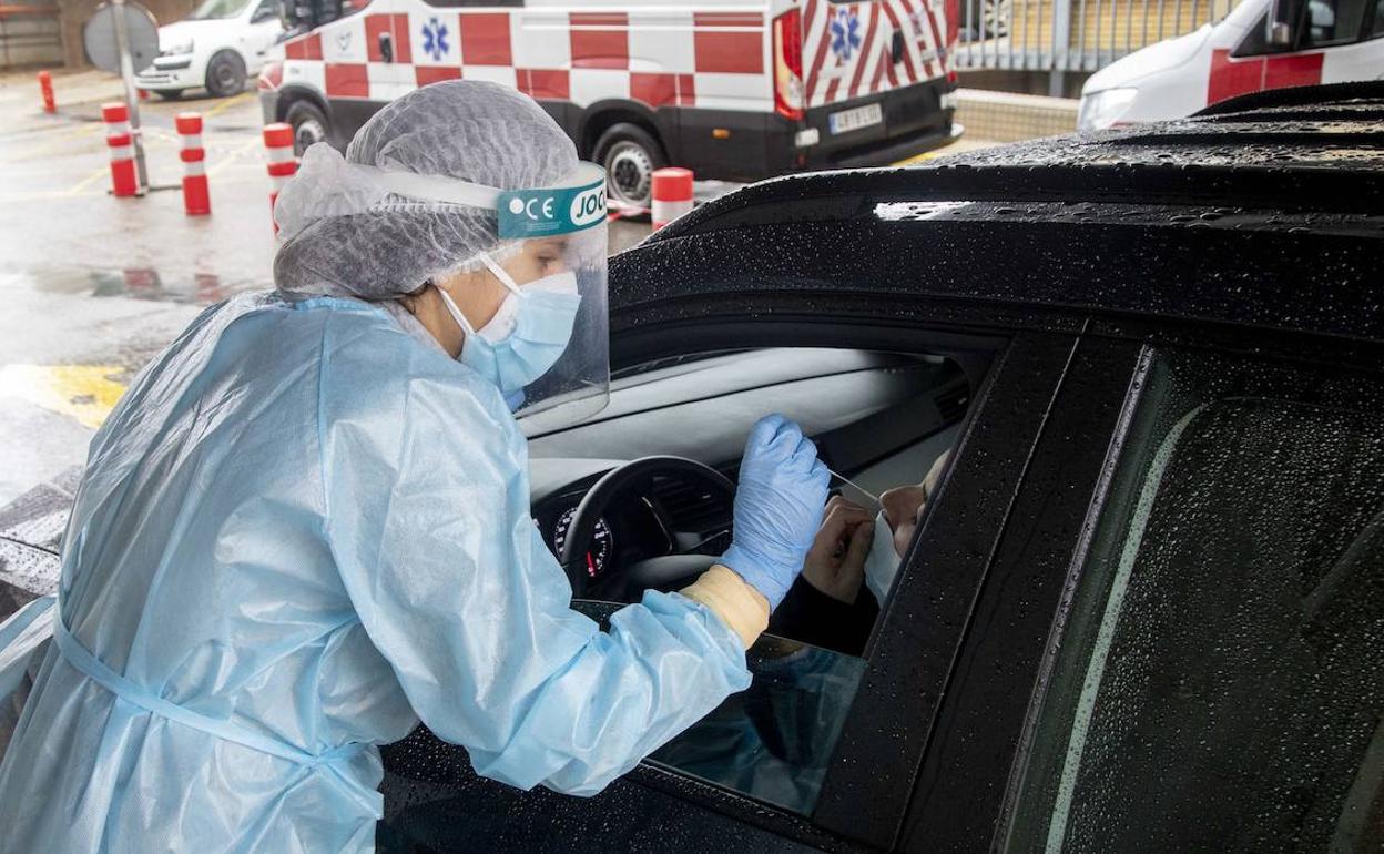 Un sanitario realiza una prueba PCR en el parking del hospital Santa María del Rosell, en Cartagena.