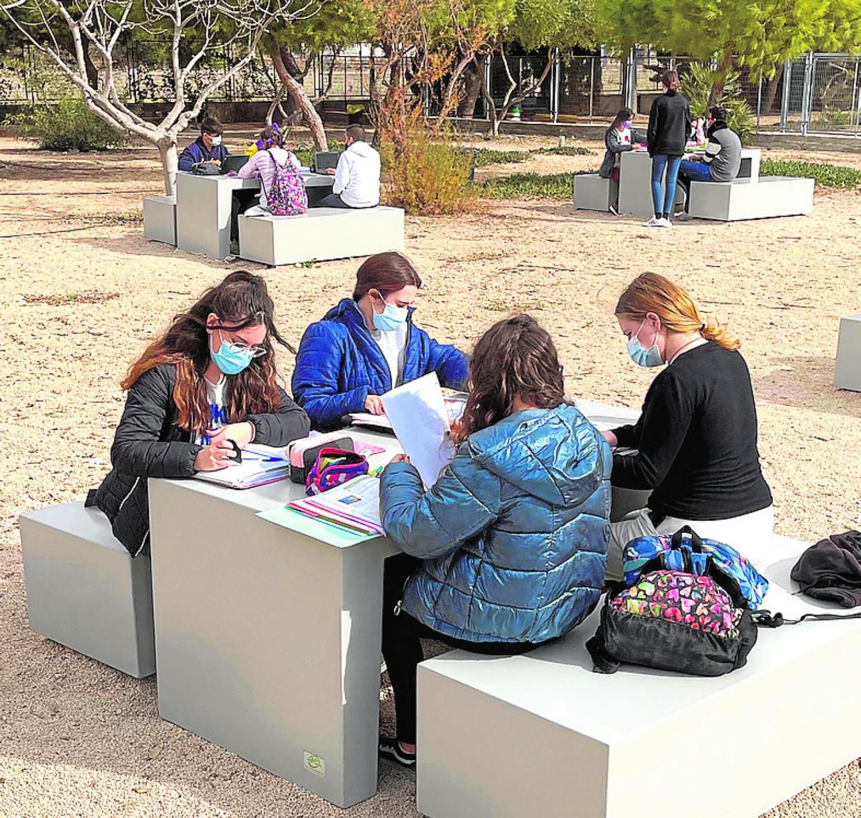 Alumnos estudiando al aire libre en sus instalaciones. 