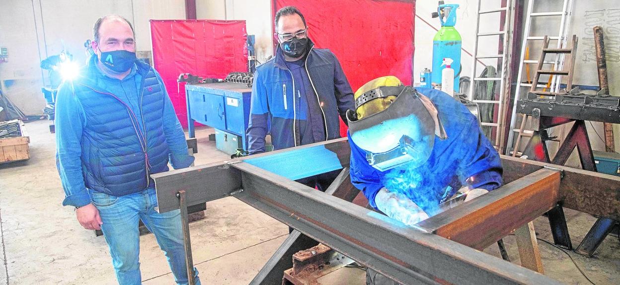 Vicente Balbín y Alfonso García supervisan a uno de sus soldadores, inmerso en el montaje de una estructura industrial, en el taller de Aralia Globa, ubicado en El Algar. 